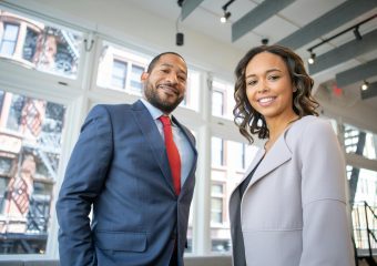 Business professionals smiling in a modern Detroit office setting.