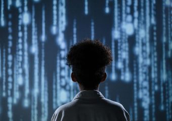 A young boy viewing a digital screen with data streams, symbolizing technology interaction.